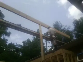 Carpenter setting a ridge beam over a new addition frame — Ice Dam Removal by Roofing Brothers in Steinauer