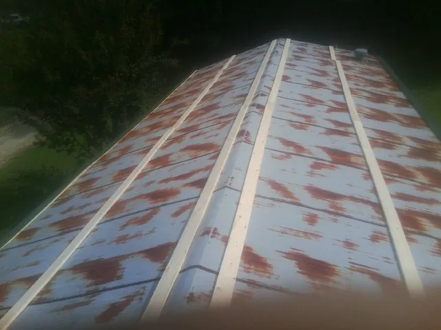 Rusted metal roof panels with new wood purlins before replacement — Storm Damage Roof Repair in Steinauer by Roofing Brothers